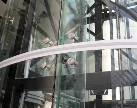Hueco de ascensor acristalado con vidrio templado sujeto con rótulas
