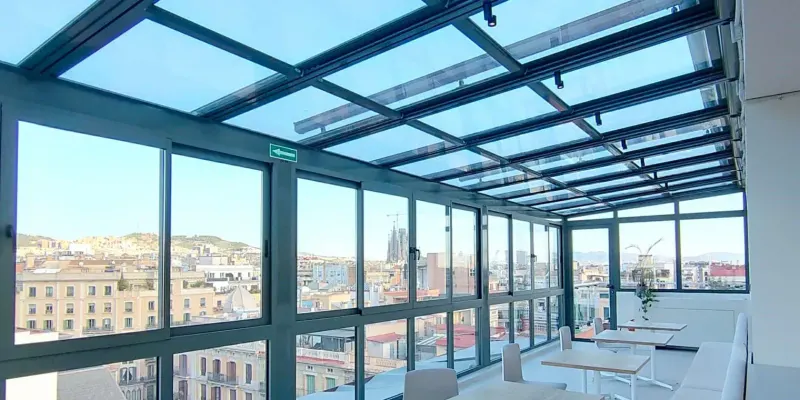Terraza con techo acristalado y ventanas de aluminio sobre la ciudad